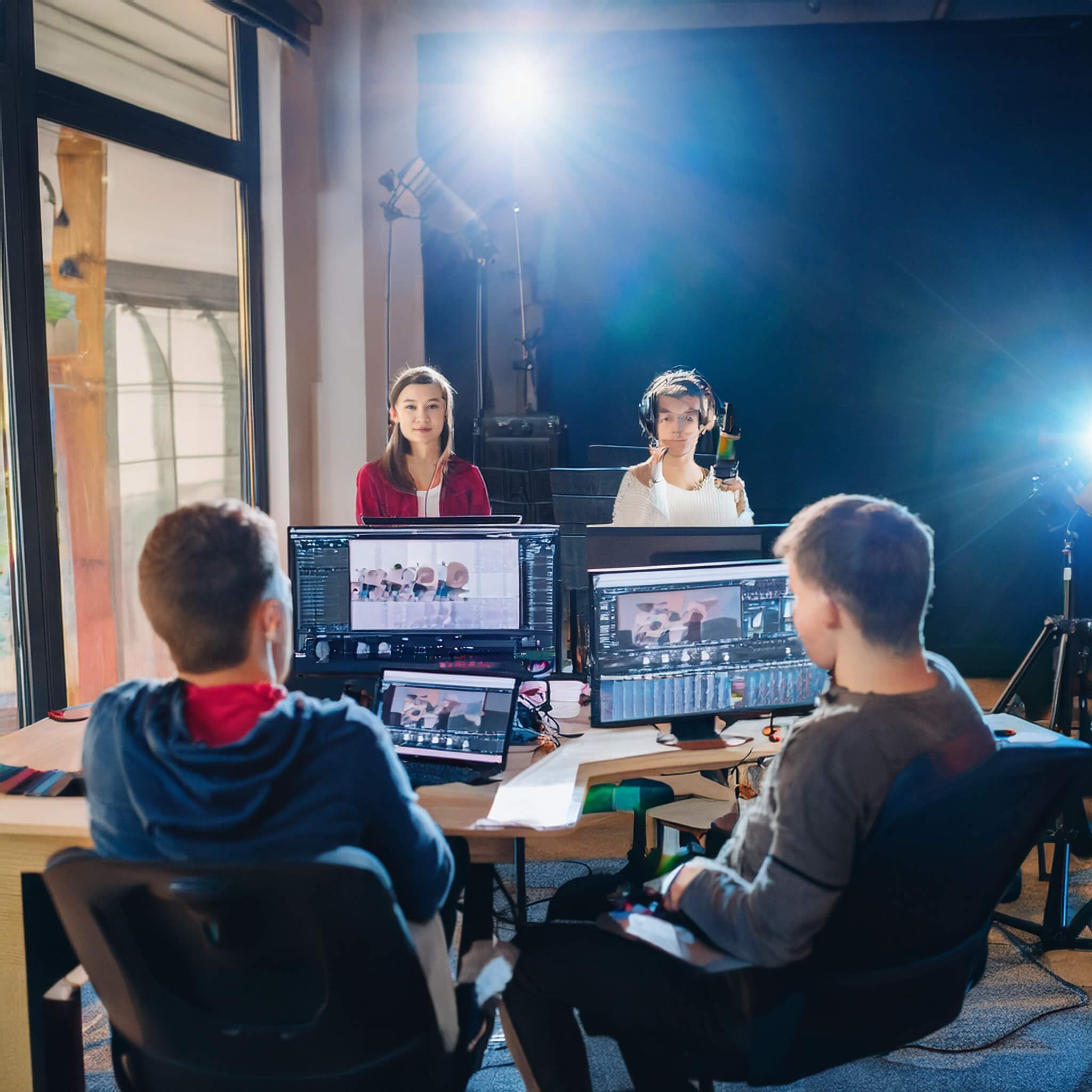 Equipo audiovisual grabando en estudio con cámaras, luces y monitores de edición.
